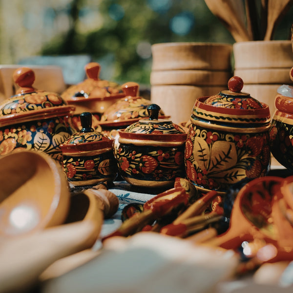 Collection of colorful ceramic pots with intricate designs on a table.