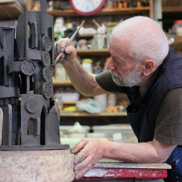 Man working with metal sculptures in a workshop setting