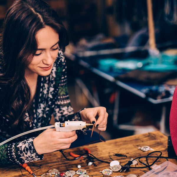 Woman working with jewelry on a wooden table